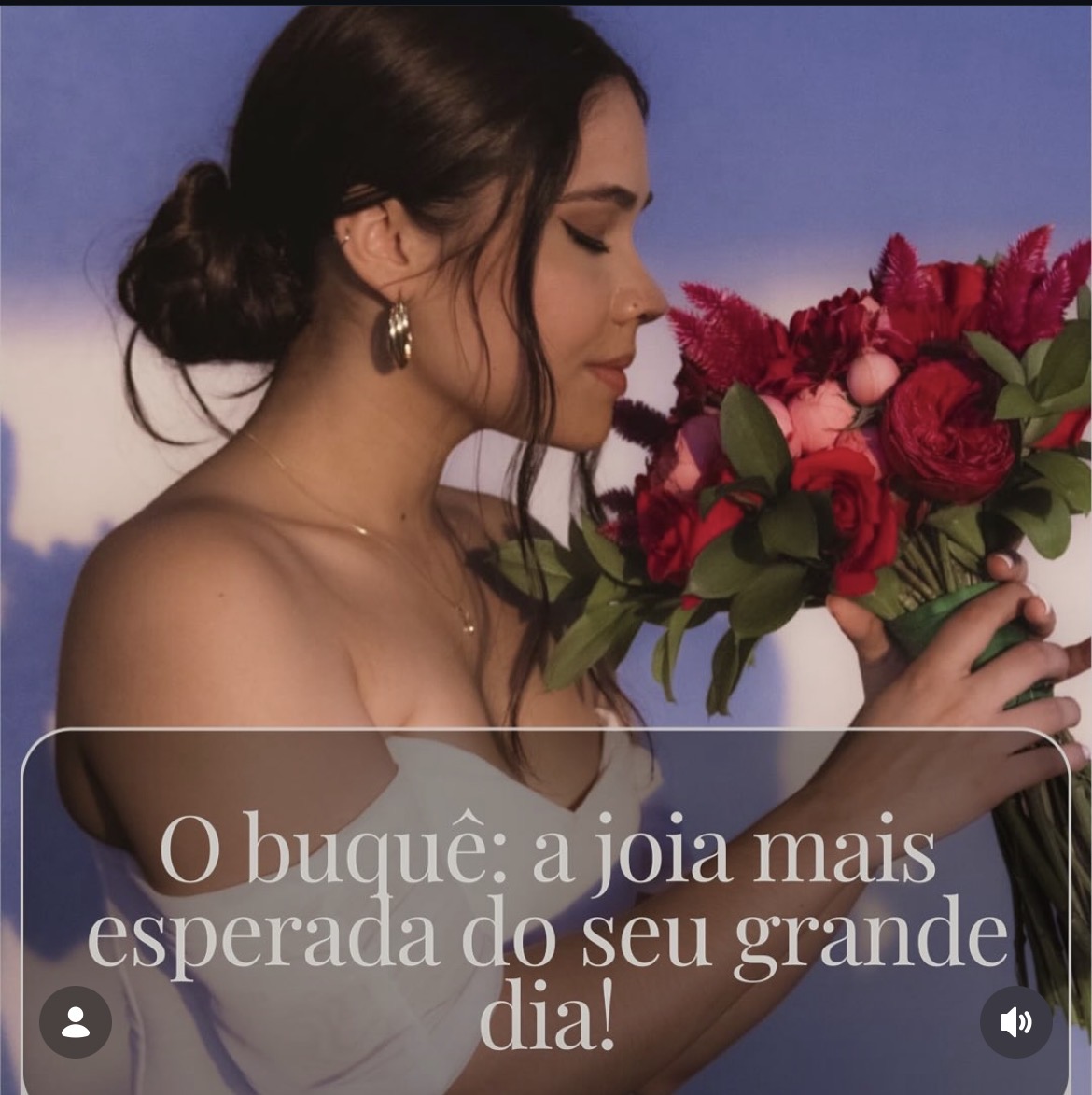 Noiva segurando um buquê de rosas em tons vermelhos
